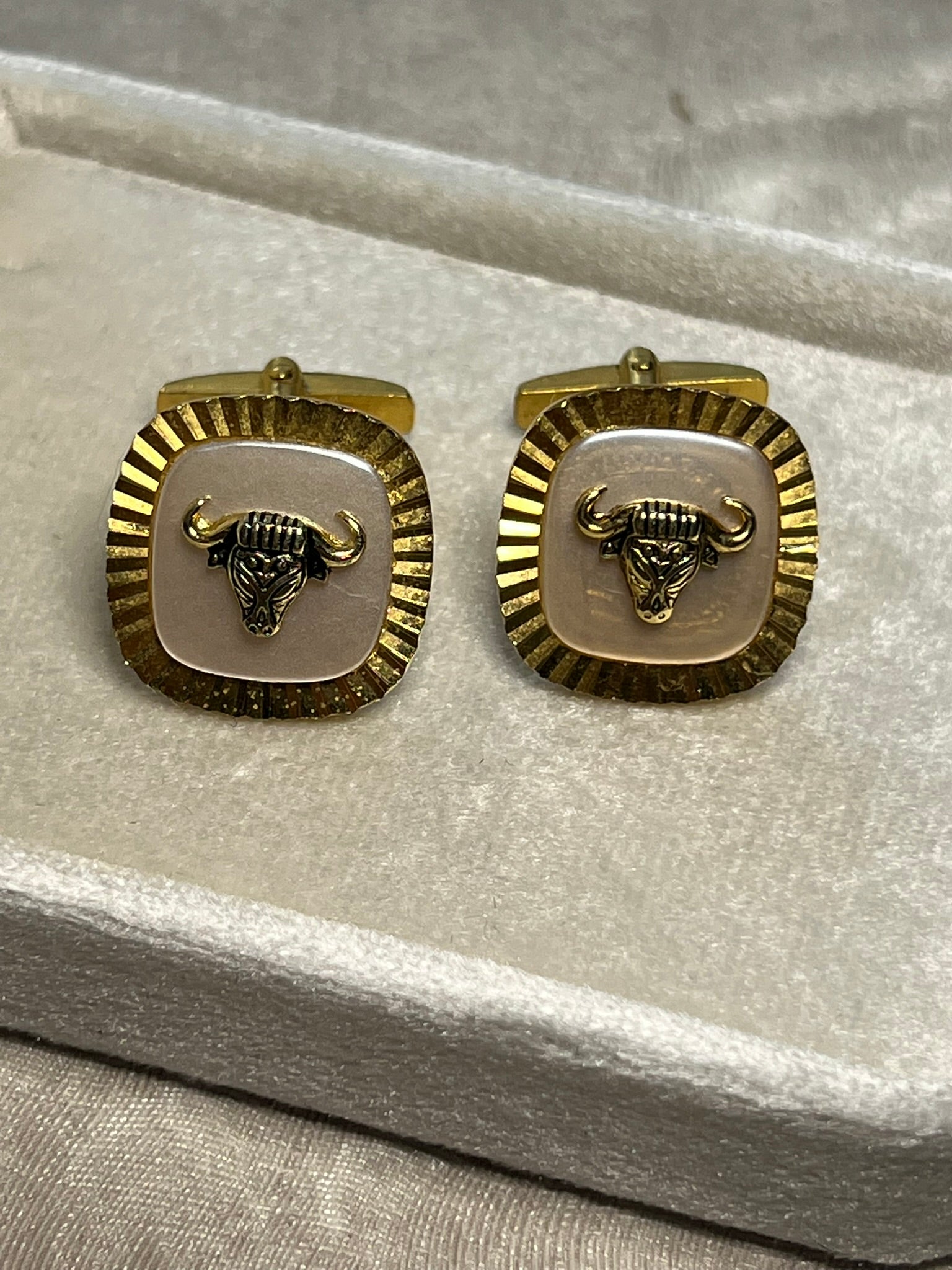 Striking vintage gold-tone cufflinks featuring a fierce bull head motif overlaid