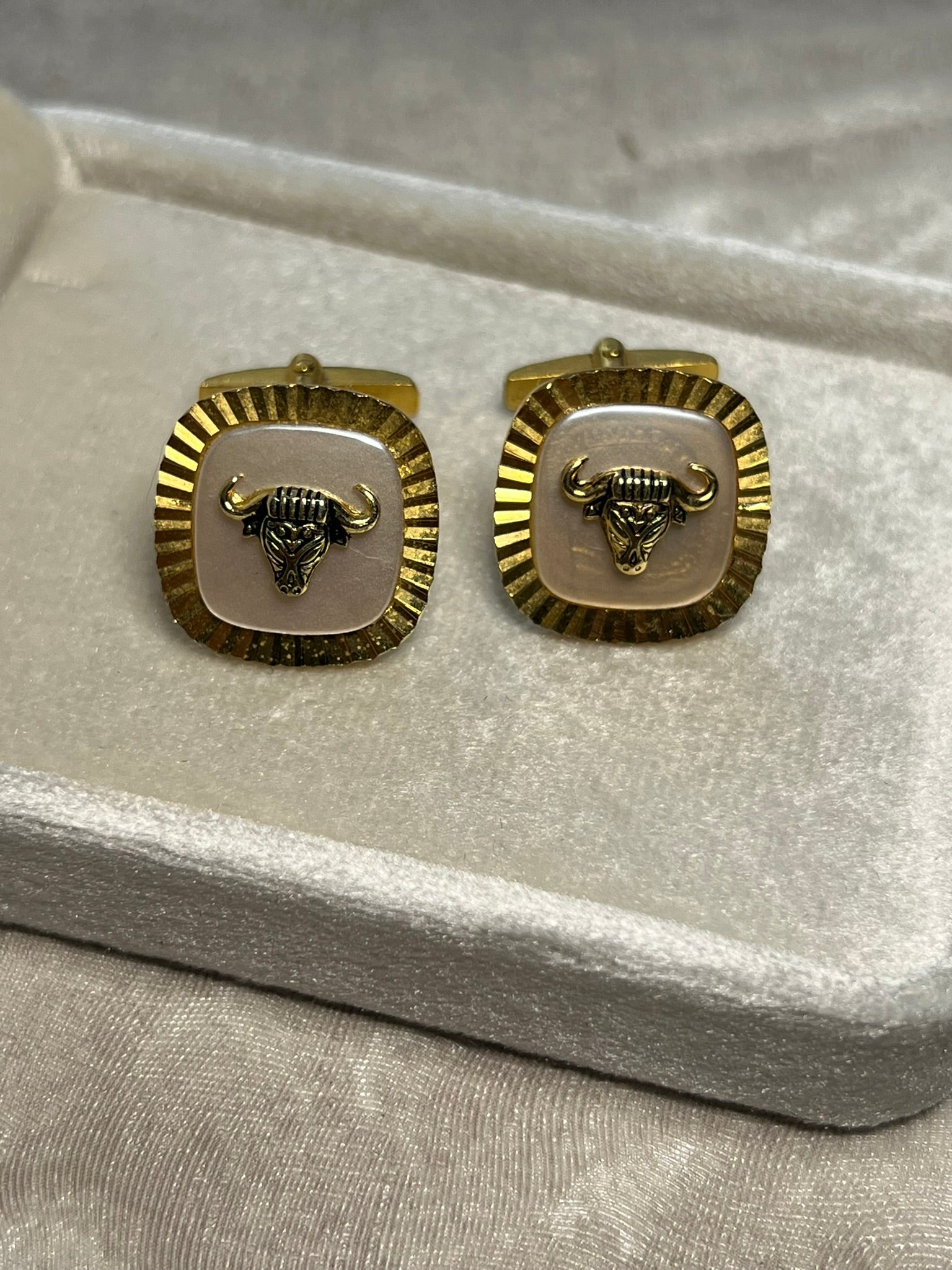 Striking vintage gold-tone cufflinks featuring a fierce bull head motif overlaid