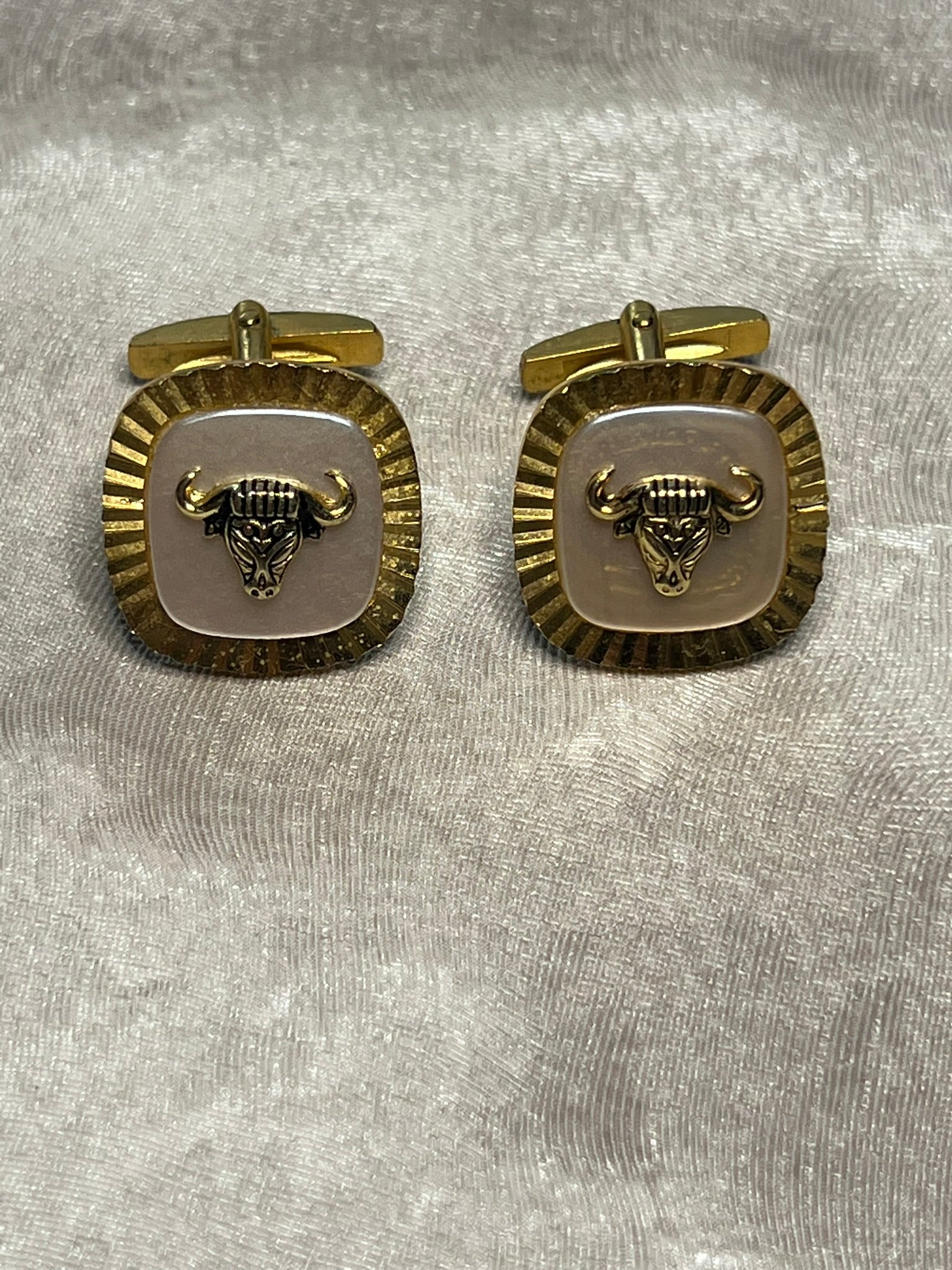 Striking vintage gold-tone cufflinks featuring a fierce bull head motif overlaid